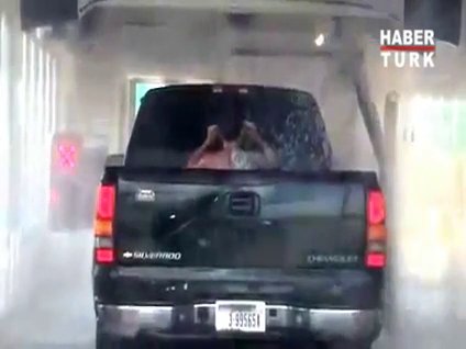 Arabasını yıkatırken kendi de yıkanan adam