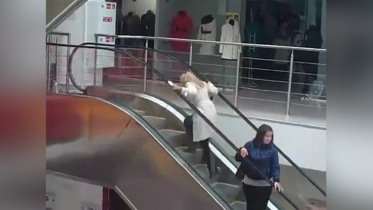 Yürüyen merdivenden tersine çıkmaya çalışan kadın