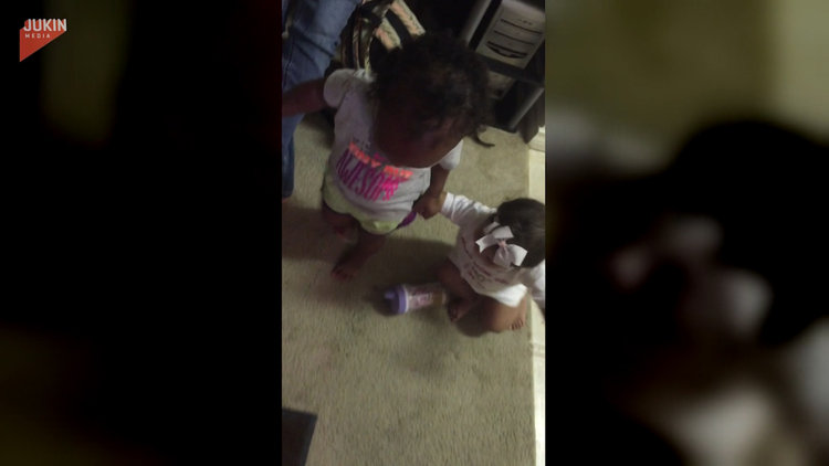 Kuzeninin yürümesine yardım eden sevimli bebek