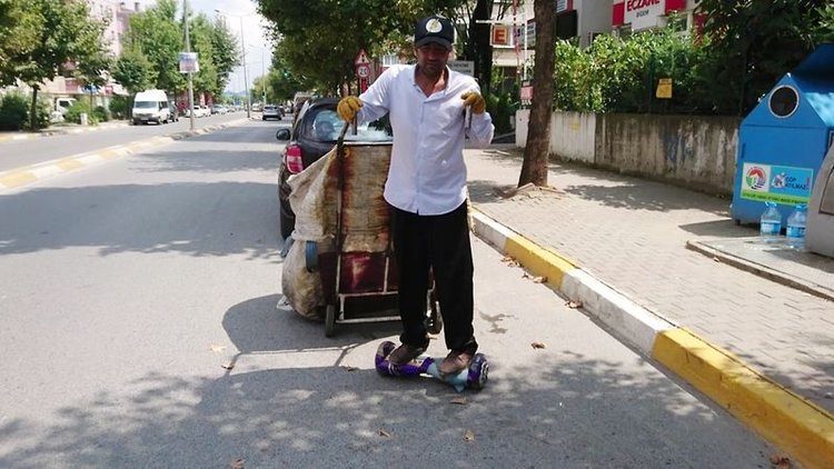 Kağıtları elektrikli kaykay ile topluyor