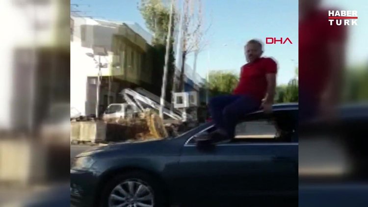 Otomobilin tavanına oturup, direksiyonu ayaklarıyla kontrol edip araç kullandı