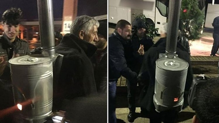 Sırtında yanan odun sobasıyla sokaklarda gezintiye çıktı