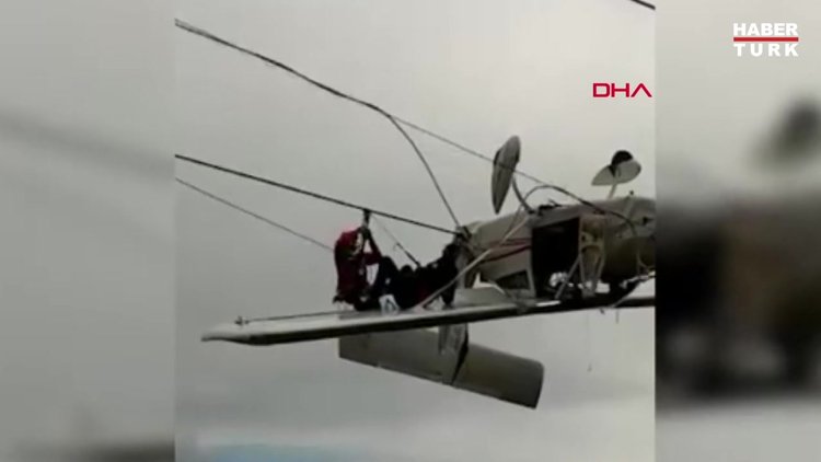 Uçak elektrik tellerinde asılı kaldı, pilot kanada oturup kurtarılmayı bekledi
