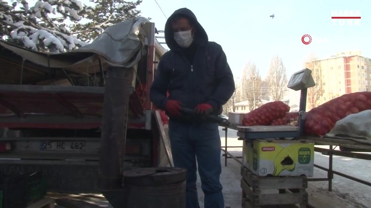 Pazarcılar soğuk havada açık alana kurdukları soba ile ısınıyor