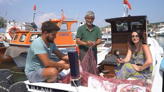 Sevcan Orhan ağ tamiri yapmakta olan bir dede torunun teknesinde Saros Körfezi'ni gezdi.