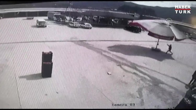 Rüzgarın etkisiyle sürüklenen şemsiyenin peşinden koşup yakaladı