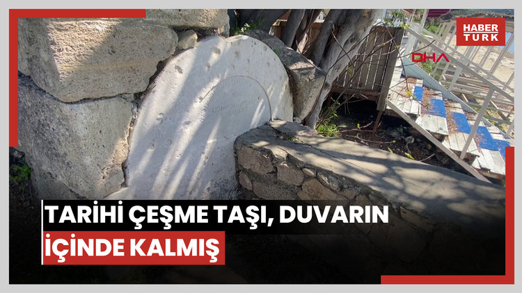 Tarihi çeşme taşı, duvarın içinde kalmış