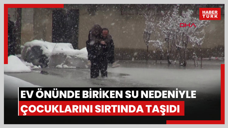 Evinin önünde biriken su nedeniyle çocuklarını sırtında taşıyor