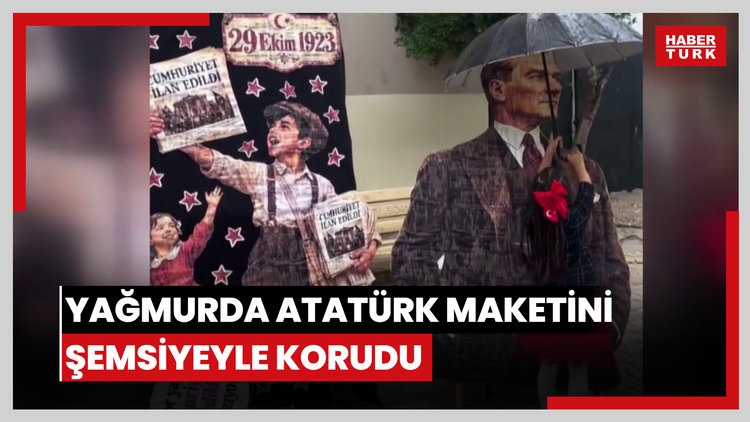 Yağmurda Atatürk maketini şemsiyeyle korudu